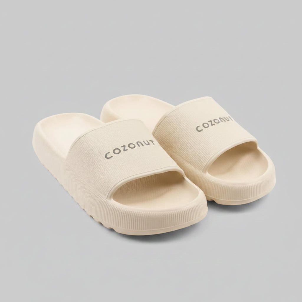 Pair of off-white slides with 'cozonut' branding on a gray background
