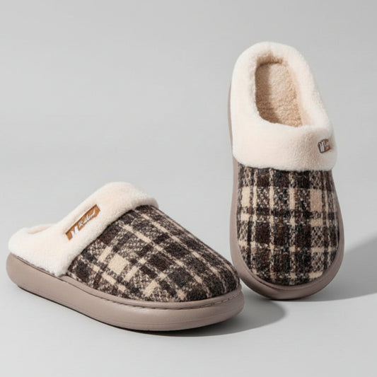 Pair of plaid patterned slippers with white fur lining on a gray background