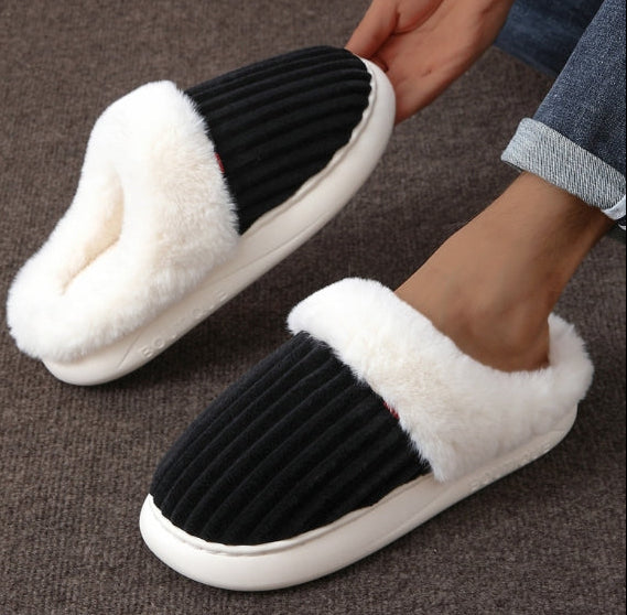 Black and white slippers with fluffy texture on a brown surface