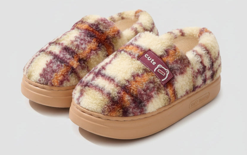 Plaid patterned slippers with a 'cute' label on a light gray background
