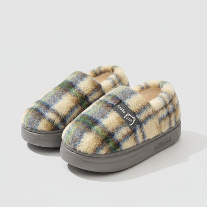 Plaid patterned slippers with 'EVA' branding on a soft surface.