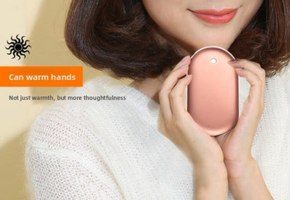 Person holding a pink hand warmer with text indicating it can warm hands and is more thoughtful.
